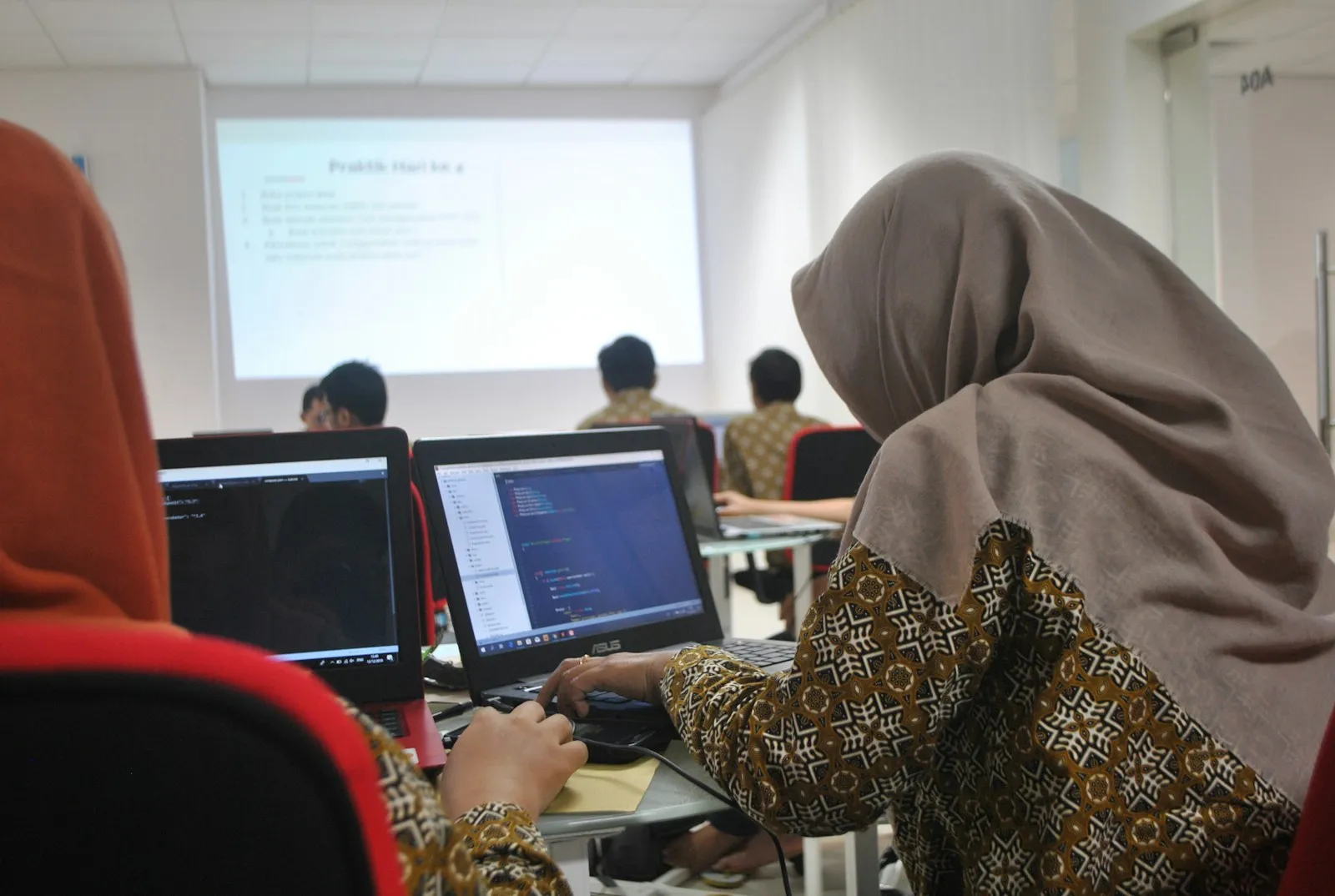 Perempuan berhijab belajar di depan laptop