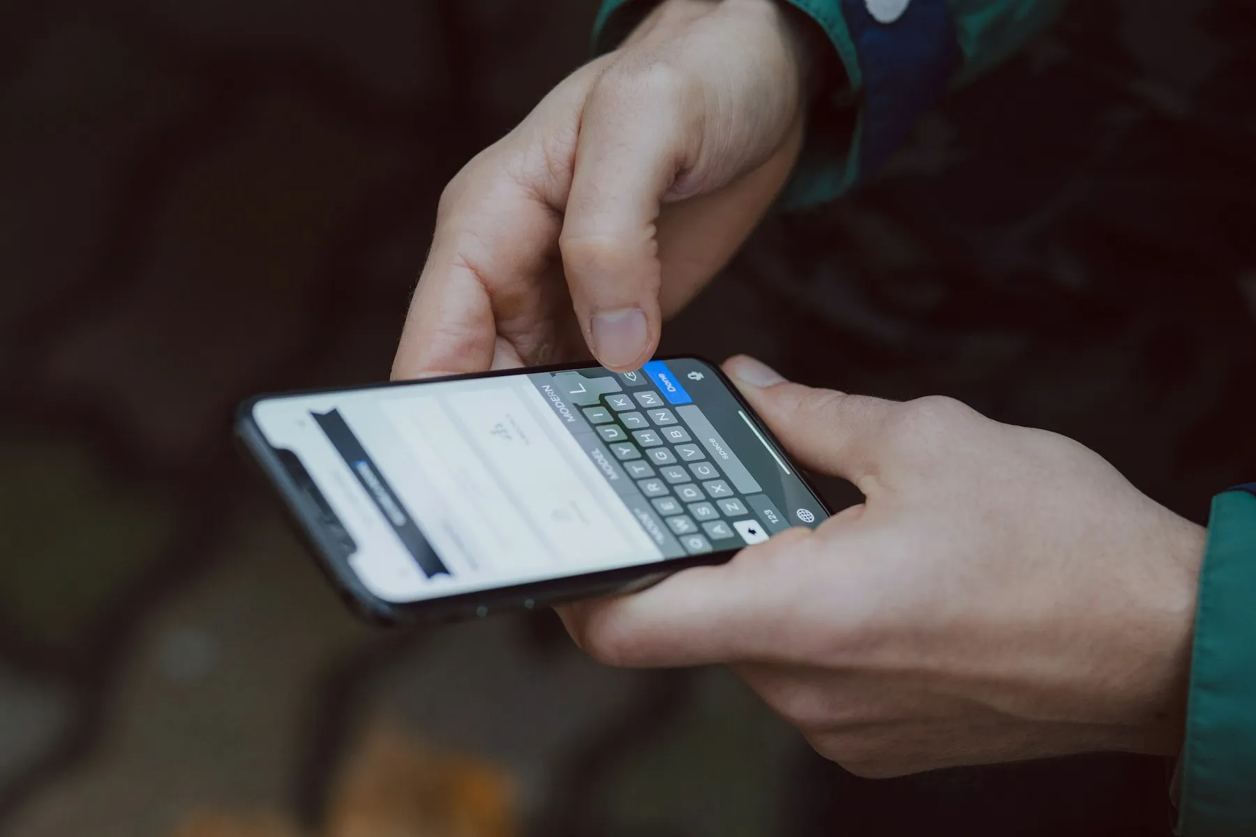 Tangan yang sedang mengetik pesan di smartphone